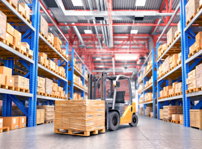 A forklift is moving boxes in an industrial warehouse.
