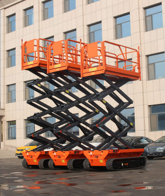 A group of three scissor lift trucks parked in front of a building.
